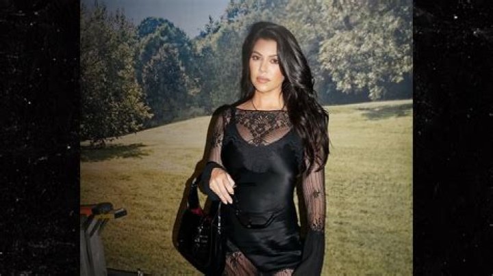 Kourtney Kardashian Stuns In Cutout Midi Dress As She Poses Seductively On Bed