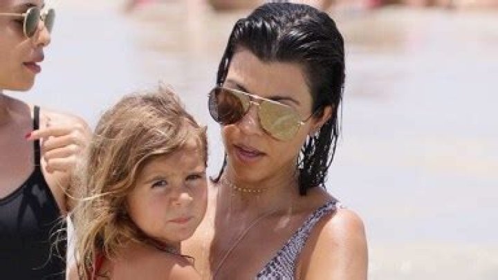 Kourtney Kardashian Wears Pink Wetsuit & Cuddles Daughter Penelope, 10, On A Boat: Photos